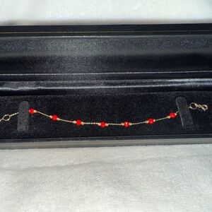 Gold bracelet with red beads